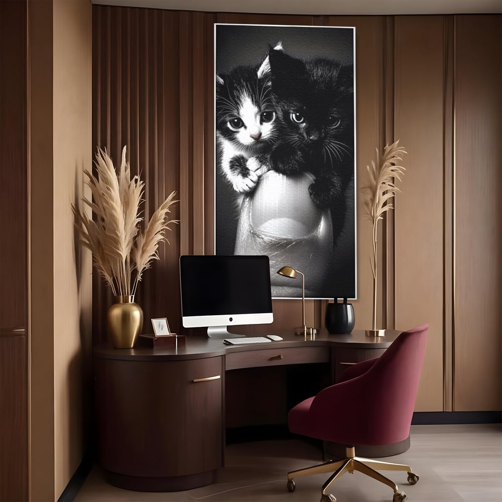 Tablou canvas cu tablou canvas cu doi pisoi mici agatati de un deget, in rama de aluminiu argintiu, pe perete intr-un birou